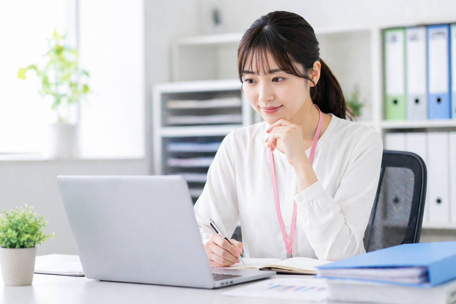 明るいオフィスでノートパソコンを使いながらメモを取る20代女性が、未経験から事務職へ挑戦する前向きな姿を表現したコラム用画像