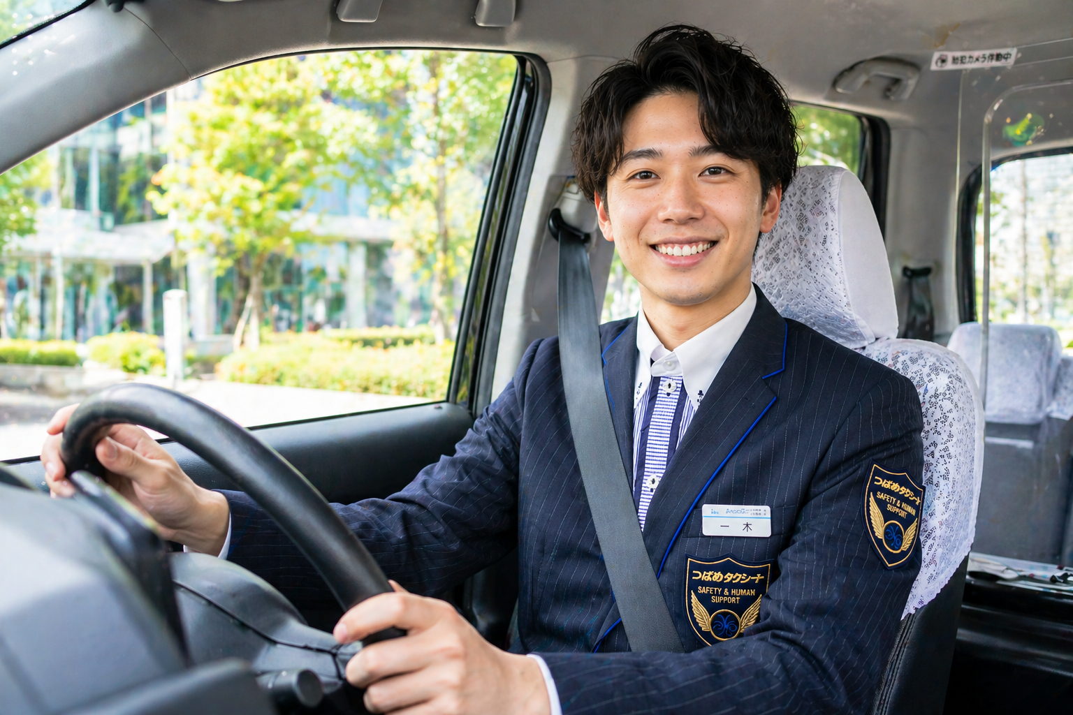 つばめグループ風の制服を着た20代男性ドライバーがタクシー車内で笑顔を見せながら運転席に座り、若手世代から注目されるタクシードライバーの魅力を表現したコラム用画像